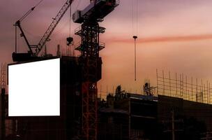 Blank white banner for advertisement hanging on the scaffolding of modern building under construction. An empty space for your content. photo