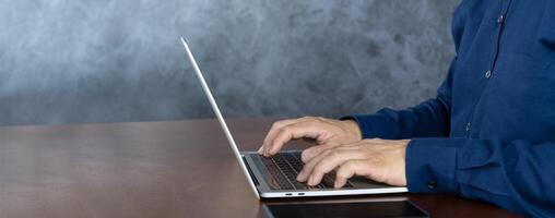 Close up businessman typing on a laptop computer at home. A man browsing the internet at home. photo