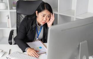 Stressed Business Woman Working at Computer in Modern Office Environment, Experiencing Work Pressure and Fatigue photo