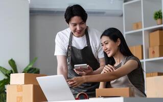 Couple Working Together on Their Online Business in a Modern Home Office with Laptops and Packaging Boxes photo