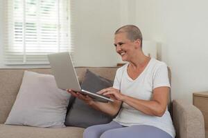 Elderly Woman Relaxing on Couch and Exploring Social Media on Laptop in Cozy Home Environment photo