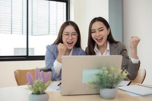 Two Female Accountant Collaborating on Financial Graphs and Data Analysis in a Modern Office Setting photo