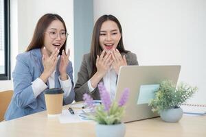 Two Female Accountant Collaborating on Financial Graphs and Data Analysis in a Modern Office Setting photo