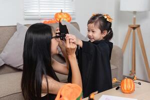 Mother and Daughter Decorating Living Room for Halloween with Costumes and Decorations, Creating Festive and Fun Atmosphere photo