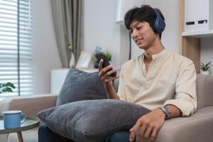 Young Man Relaxing in His Modern Room, Enjoying Free Time with Smartphone and Headphones, Comfortable and Casual photo