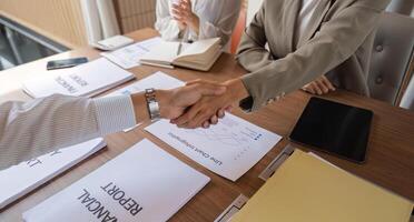 Businessmen Shaking Hands During a Meeting to Exchange Ideas and Discuss Financial Reports in a Modern Office Setting photo
