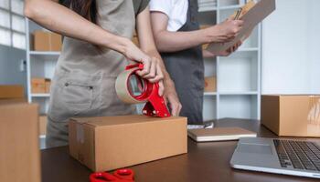 Couple Packing Boxes of Merchandise for Online Business in Modern Home Office Setting photo