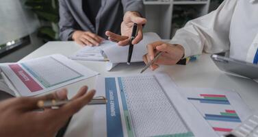 Asian Businessmen Team Meeting to Discuss and Exchange Ideas with Documents and Charts on the Table photo