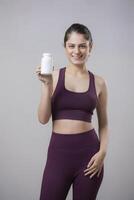 Gym Model Showing Supplement Bottle In Front Of The Camera photo