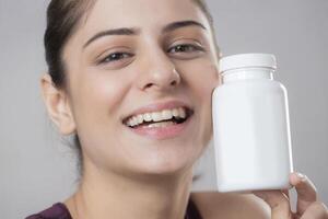 A Close-up Image Of A Gorgeous Woman Flaunting A Vitamin Bottle In Front Of The Camera photo