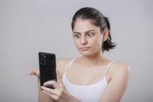 A Beautiful Indian Model Giving A Shocked Reaction While Looking At Her Phone photo
