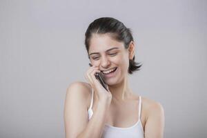 A Glamorous Woman Smiling While Talking On The Phone photo