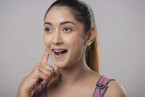 Shy Attractive Woman Looking Beside With One Finger On Her Face photo
