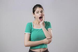 Shocked Woman Standing On A Grey Background photo