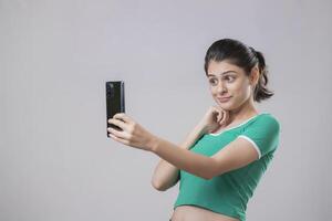 Pretty Blonde Woman With One Hand On Her Chin And The Phone In The Other photo