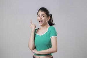 Charming Model Raises Her Fore Finger Up In Surprise Of Getting A New Idea photo
