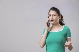 A Sweet Model With Shocked Face Expression While Talking On Phone With Someone photo