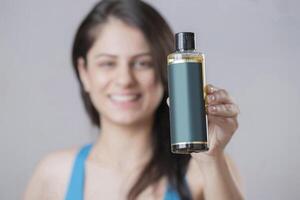 Close Up Photoshoot Of Attractive Girl Holding Oil Bottle In Hand photo