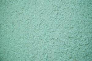 An aesthetically pleasing textured mint green wall surface featuring subtle, intricate patterns photo