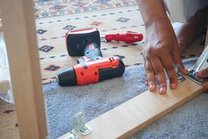 Expertly assembling furniture with power tools while surrounded by a cozy, inviting setting photo
