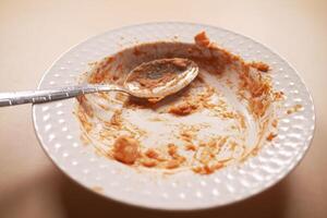 An empty dirty plate with a fork. photo