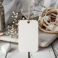 White tag mockup with twine bow on white marble background. photo