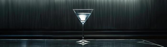 Martini glass on a bar counter with a dark background photo