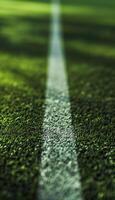 Close up of white line marking on green turf of soccer field photo
