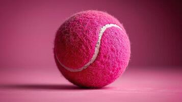 A pink tennis ball on a pink background. photo