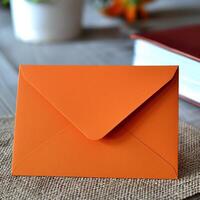 An orange envelope sits on a burlap cloth photo