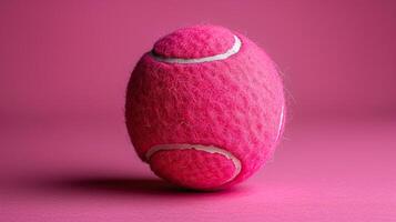 A pink tennis ball on a pink background photo