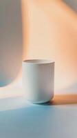 A simple white cup sits on a table with a colorful gradient background. photo