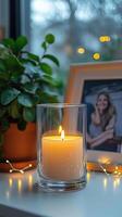 Blank clear straight candle glass surrounded by a stack of books, a small vase with flowers, and warm ambient lighting, modern warm bedroom mockup, chic and cozy photo