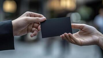 a photo of someone handing another person a black business card