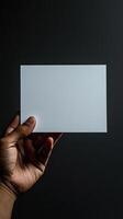 a hand holding a white blank rectangle paper, paper position horizontally, realistic photo