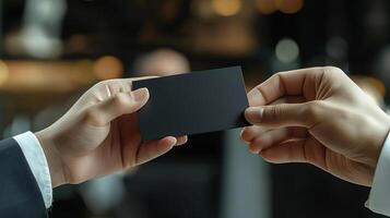 a photo of someone handing another person a black business card