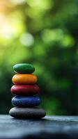 A calming stack of colorful stones on a blurred green background, symbolizing balance and harmony in nature. photo