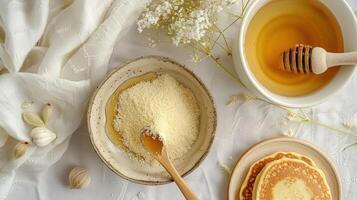 Honey and powdered sugar on a table with a stack of pancakes. photo