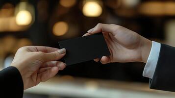 a photo of someone handing another person a black business card