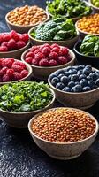A rainbow of healthy ingredients including berries, lentils, and greens, artistically arranged in bowls on a dark, textured surface, symbolizing balanced and vibrant nutrition photo