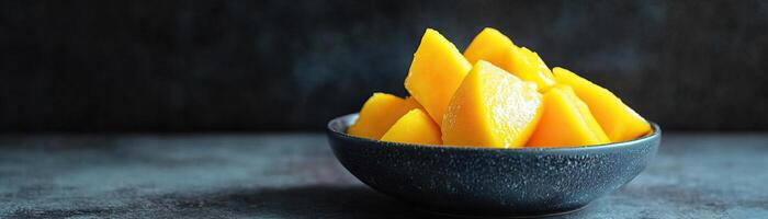 A vibrant bowl of fresh mango slices, showcasing their rich yellow color and juicy texture, perfect for summer dishes and desserts. photo