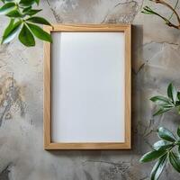 A wooden frame on a concrete wall with green leaves. photo