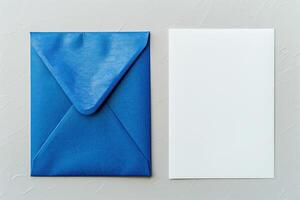 A blue envelope and a blank white card on a gray stone background. photo