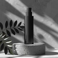 A black bottle on a marble podium with a plant next to it. photo