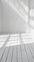 bright, empty room with white walls and wooden floor. The room is lit by natural sunlight streaming in through the windows. photo