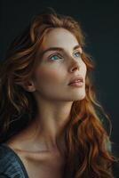 A beautiful redhead woman with blue eyes is looking up at something off camera. photo