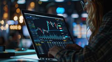 A focused individual analyzes stock market trends on a laptop in a lively office environment, illuminated by ambient lights. photo