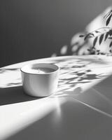 A white candle on a white table next to a plant photo