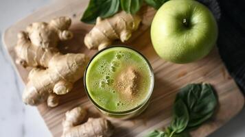 A glass of green smoothie next to a green apple, ginger, and basil on a wooden cutting board. photo