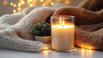 Blank clear straight candle glass surrounded by a stack of books, a small vase with flowers, and warm ambient lighting, modern warm bedroom mockup, chic and cozy photo